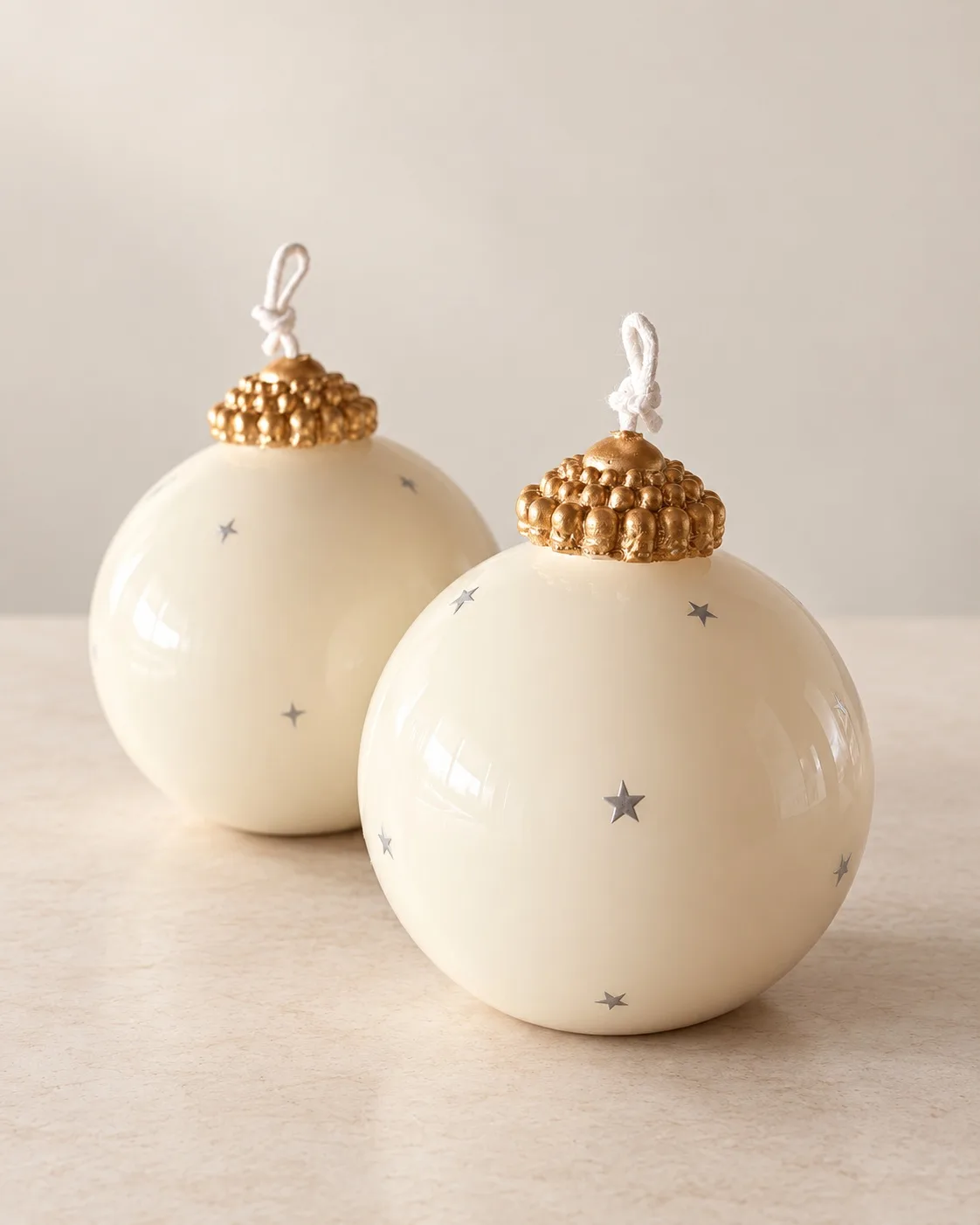 Vela em forma de bola de Natal com estrelas e detalhes dourados