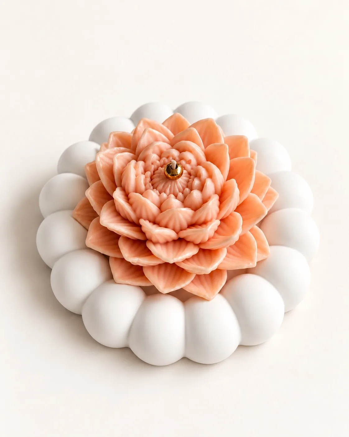 Vela em forma de flor de lótus cor de pêssego sobre prato de gesso branco