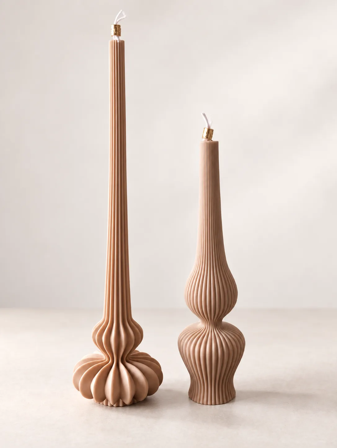 Duas velas altas caneladas em tom nude